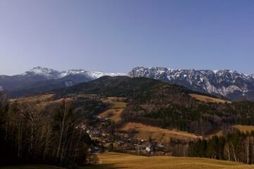 green hilly landscape with high mountains on the horizon
