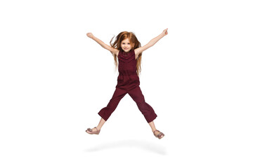 Fototapeta na wymiar Jumping, running. Happy, smiley little caucasian girl isolated on white studio background with copyspace for ad. Looks happy, cheerful. Childhood, education, human emotions, facial expression concept.