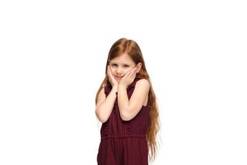 Fototapeta premium Shy, astonished. Happy, smiley little caucasian girl isolated on white studio background with copyspace for ad. Looks happy, cheerful. Childhood, education, human emotions, facial expression concept.