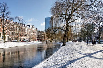 Rotterdam, The Netherlands, February 10, 2021: Spoorsingel canal in Provenierswijk neighbourhood, with ice and snow and in the background the downtown highrise - Powered by Adobe