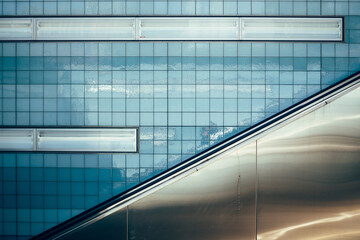 part of escalator in fron of blue tiles