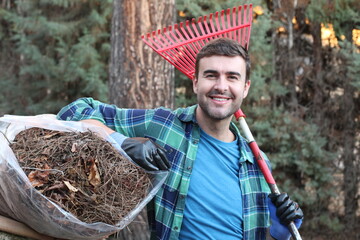 Man sweeping leaves in backyard 