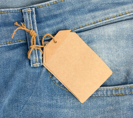 blank cardboard rectangular tag tied to blue jeans