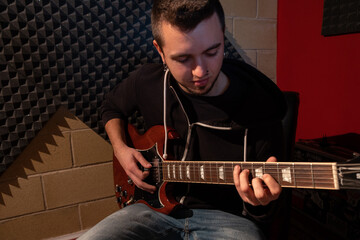 Man playing the guitar at the studio