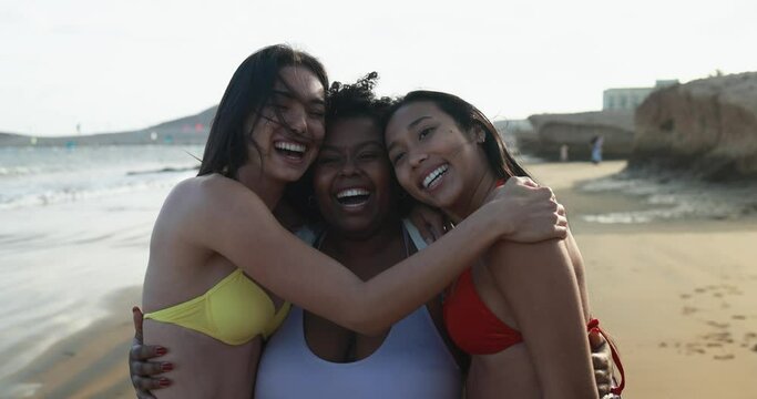 Happy multiracial women with different bodies having fun in summer day on the beach