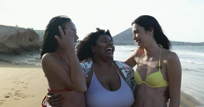 Happy multiracial women with different bodies having fun in summer day on the beach
