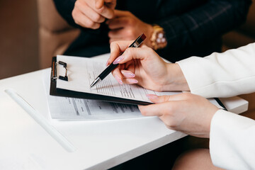 Salesmen are letting the male customers sign the sales contract. Business concept and contract...