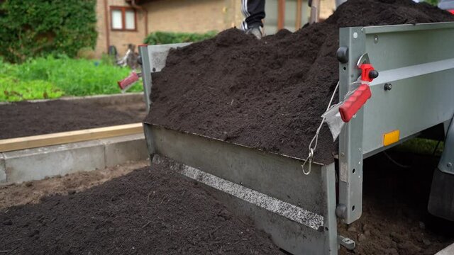 Unloading Delivery Of Topsoil From Trailer By Hand, Handheld Shot