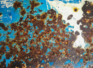 The old blue colored surface peels off the metal surface caused by rust corrosion.