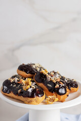 Traditional french dessert - eclairs with chocolate glaze on marble background