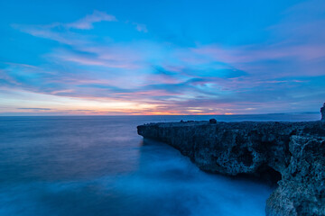 coral jutting into the sea with a sunset background