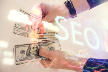 Multi exposure of seo drawing hologram and us dollars bills and man hands.