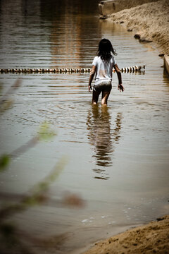 Una ni&ntilde;a peque&ntilde;a corriendo en las orillas de un lago en Valladolid, Castilla y Le&oacute;n, Espa&ntilde;a
