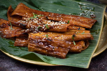 Tofu skins yuba rolls glazed and roasted, served with rice, edamame
