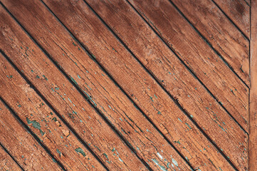 Fototapeta na wymiar Old background with wooden boards with cracked, peeled red paint, vintage texture, rough textured surface close-up.