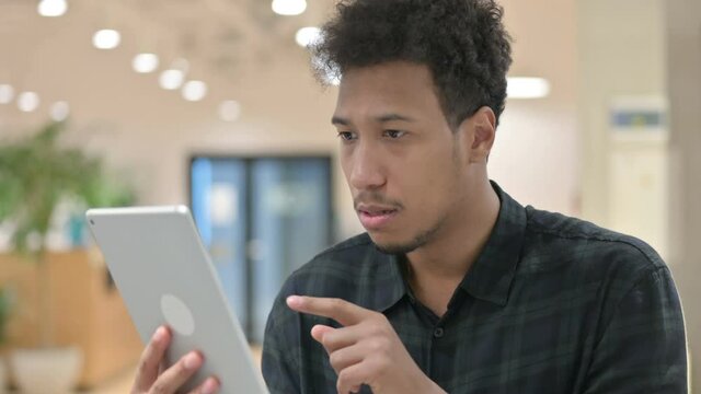 African American Man Reacting to Loss on Digital Tablet