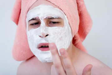 Man with a mask on his face. Applying the mask with a brush on the face. Cosmetics for men. Relaxation from cosmetic procedures. Cleaning the face mask.