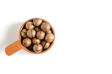 sweet macadamia nut in a brown dish on a white background concept macadamia nut