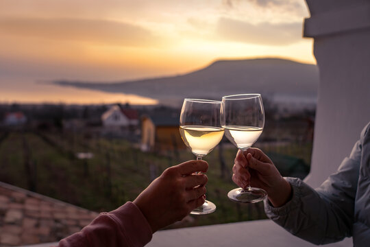 toast with wine glasses at lake Balaton with the Badacsony hill in the background