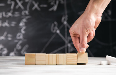 man holding wooden cubes with board