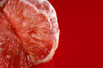 peeled grapefruit filling on a glossy red background close up macro