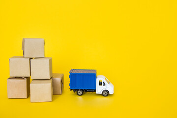 Carton boxes and post truck on yellow background. Cargo transportation, delivery service.