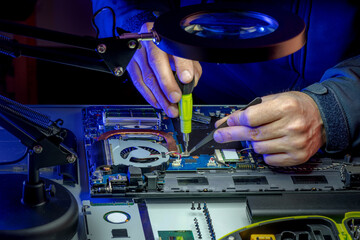 IT specialist replacing details in computer repair workshop