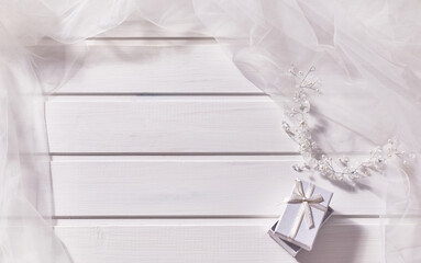 Jewelry made of beads, gift box, veil on a white wooden background.