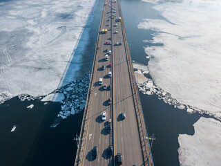 North bridge over the Dnieper river in Kiev. Aerial drone view. Sunny spring day. Crack ice melts on the river.