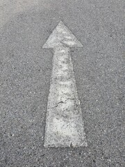 The old white arrow direct traffic sign on the road.