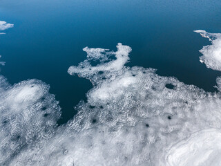 Ice melts on the river. Ice crack. Aerial drone view. Spring sunny morning.