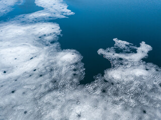 Ice melts on the river. Ice crack. Aerial drone view. Spring sunny morning.