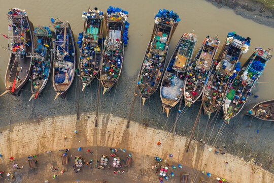 Aerial view of a line of fishing boat docket at Rahman fish market along the Karnaphuli River in Chittagong, Bangladesh.