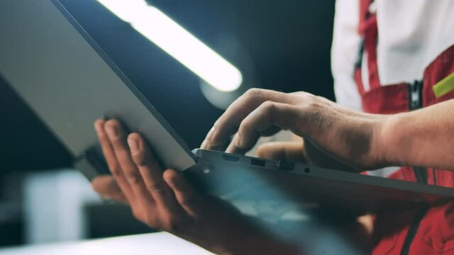 Close up of a male engineer typing on a laptop