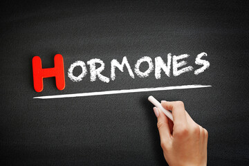 Hormones text on blackboard, concept background