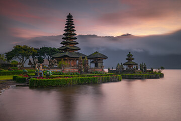 Pura Ulun Danu Bratan temple in Bali island. Beautiful balinese temple during sunrise. Balinese landmark. Cloudy sky. Water reflection. Slow shutter speed. Bratan lake, Bali