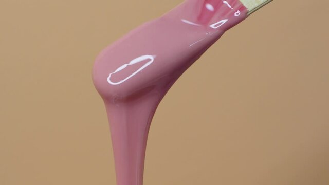 Depilatory wax master mixes heating wax with a wooden spatula. Removing unwanted hair with wax. Woman beauty
