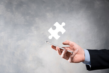 Businessman hands connecting puzzle pieces representing the merging of two companies or joint venture, partnership, Mergers and acquisition concept.