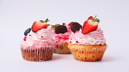 Sweet cake on a white background. Strawberry cake. Three cakes on a white plate. Background with cakes for a postcard.