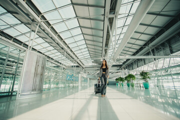 Young Asian woman dragging luggage in the airport