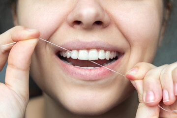 A cropped shot of a young beautiful woman flossing her teeth. Close-up. Dental concept