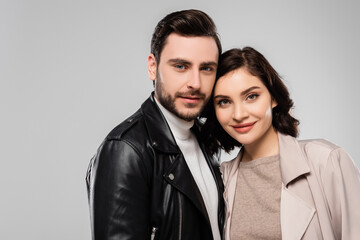 Young stylish couple looking at camera isolated on grey