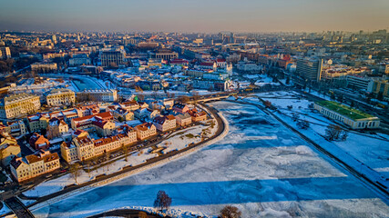 Panoramic cityscape of Minsk downtown at sunset. Old suburbs on the shore of a frozen river.