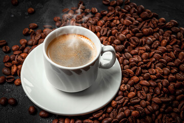 Cup of hot black coffee and roasted coffee beans close up
