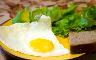 Delicious breakfast: egg, green salad, avocado and a slice of wholegrain bread