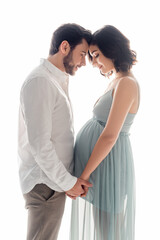 Side view of pregnant woman holding hands of husband isolated on white