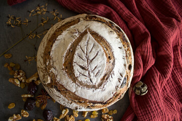 Long-fermented sourdough loaf top view photo. Beautiful round whole grain bread on a table. Still life food.  Healthy eating concept. 
