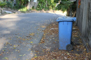 Obraz premium Blue trash bin on the roadside