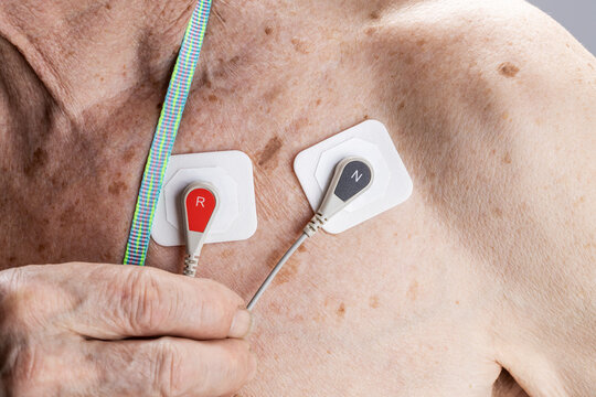 cardiology monitoring equipment ecg holter monitor. senior adult men with cardio monitor on his chest. 24 hours cardio recorder