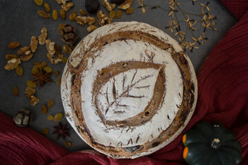 Sourdough bread with a leaf pattern on the top. Whole grain bread with black olives, raisins and nuts. Healthy eating concept.